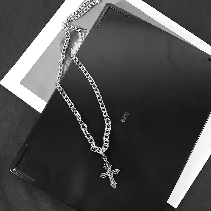Chunky cross necklace draped on black tablet.