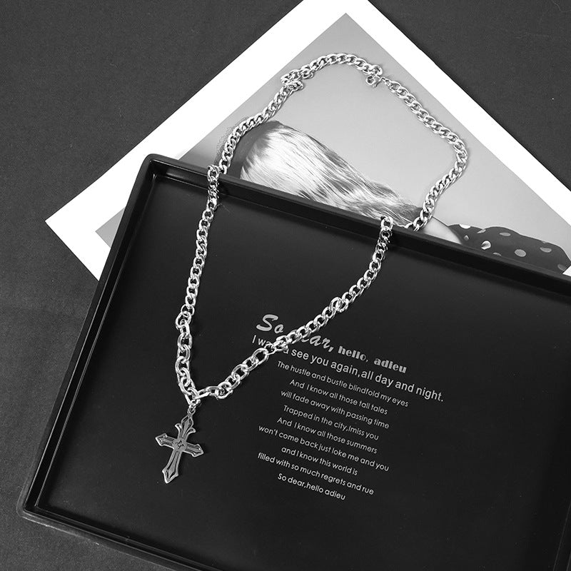 Silver chunky cross necklace styled on tray background.