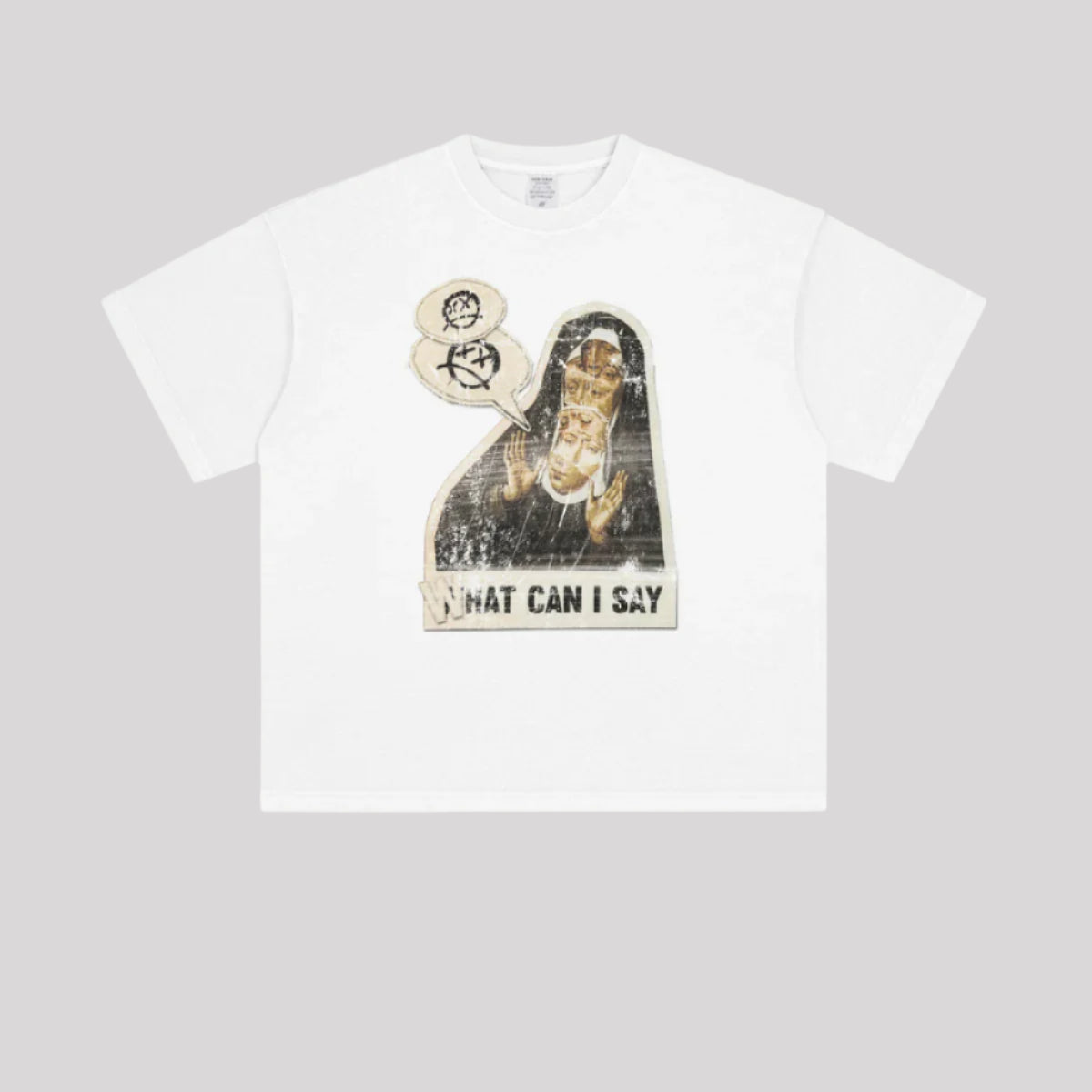 A white oversized graphic t-shirt with 'WHAT CAN I SAY' print displayed flat against grey background. Shows boxy fit and crew neckline