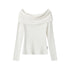 Off-white, long-sleeve, off-the-shoulder top with a wide neckline on a plain background.