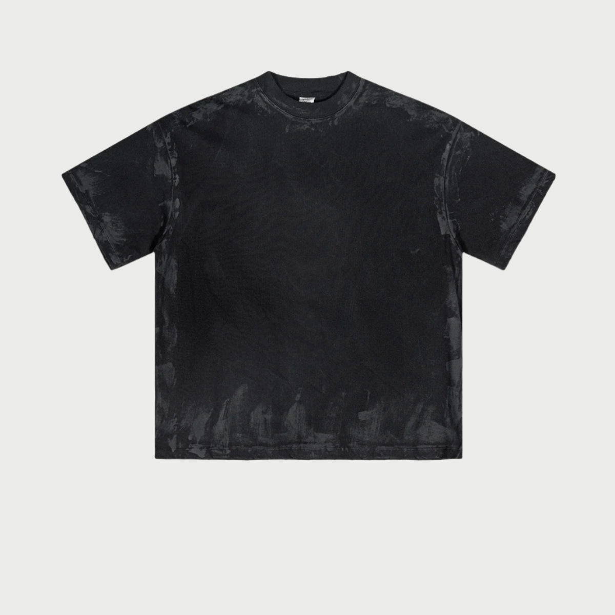 Black oversized t-shirt displayed flat showing washed effect and boxy silhouette against white background. Features crew neckline