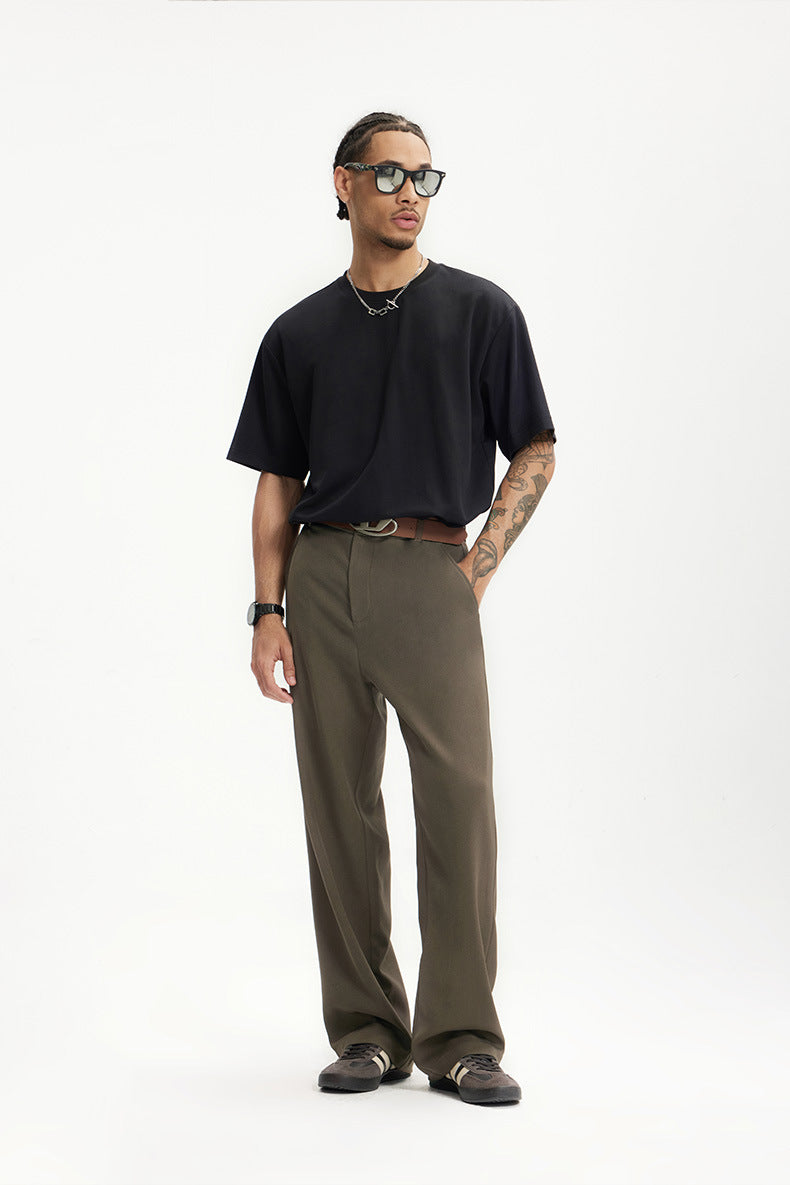 Model in dark brown mens dress pants paired with black shirt and sunglasses