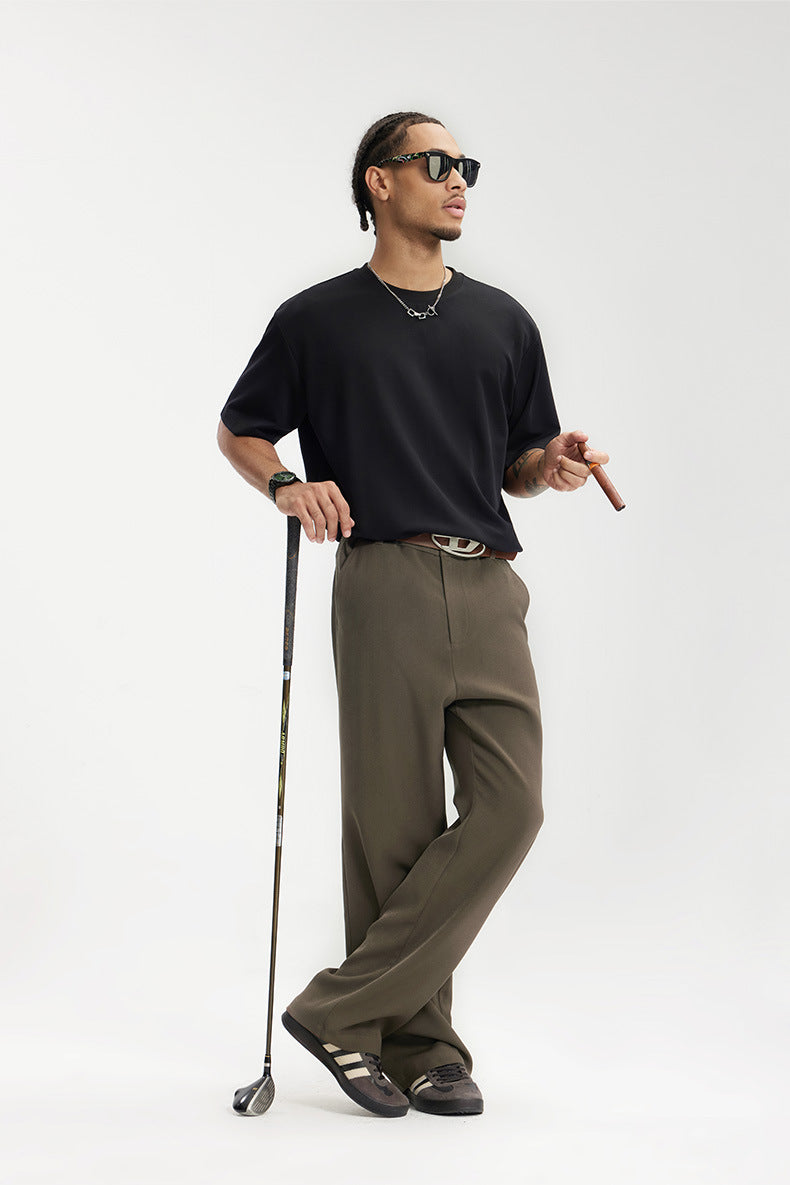 Model in dark brown mens dress pants holding golf club, casual smart look