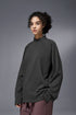 Person wearing a dark gray half-zip long-sleeve tshirt against a gray background