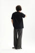 Back view of dark gray mens dress pants with black T-shirt outfit
