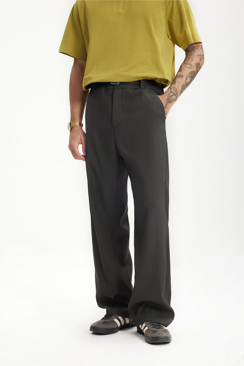 Model in dark gray mens dress pants with yellow polo shirt front view