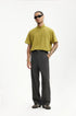 Model in dark gray mens dress pants with yellow polo shirt, minimal styling
