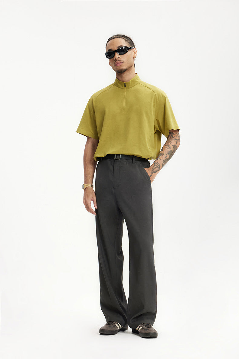 Model in dark gray mens dress pants with yellow polo shirt, minimal styling