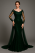 Woman wearing dark green evening gown with sheer sleeves against a gray background