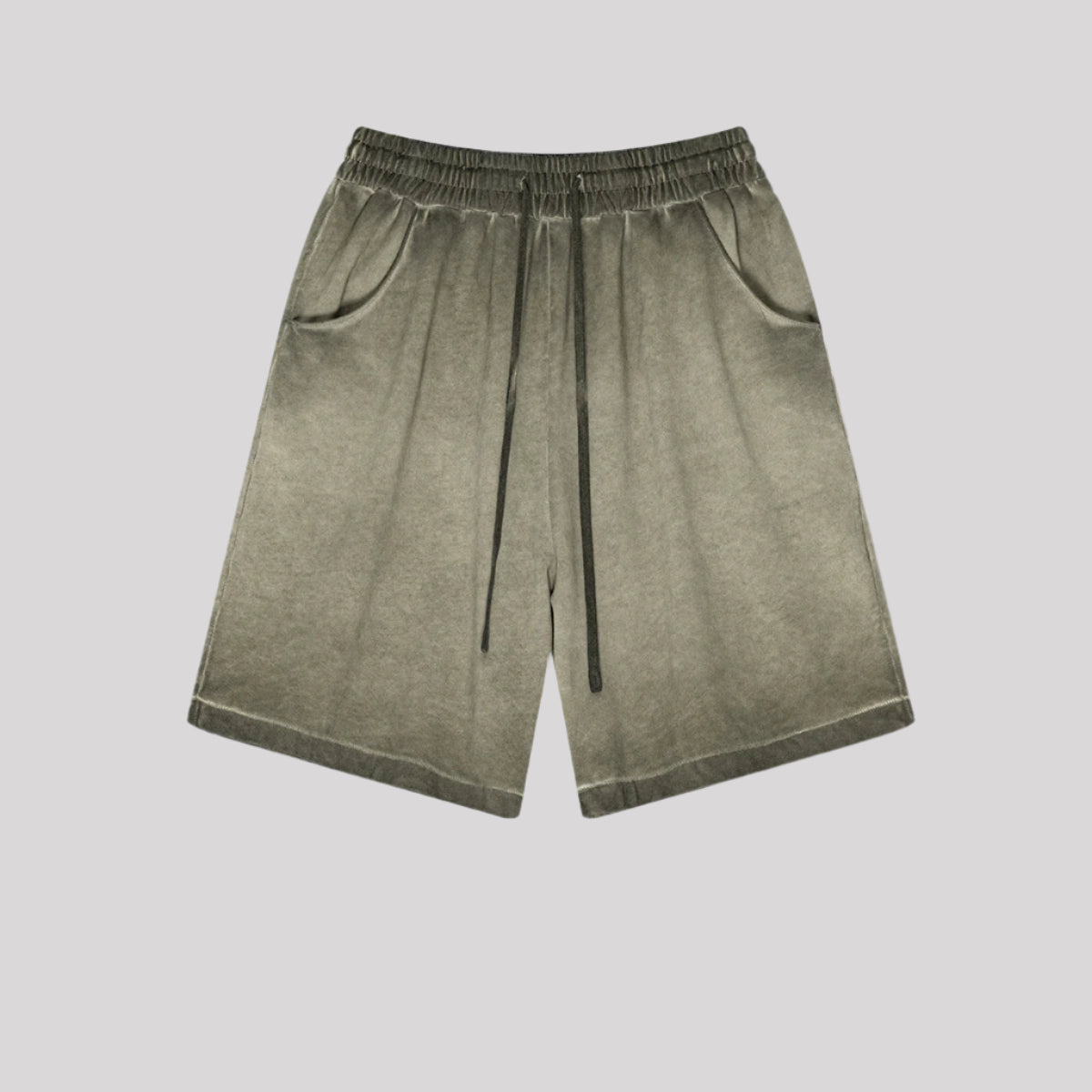 Olive green washed cotton shorts with elastic waistband and side pockets displayed flat against light gray background