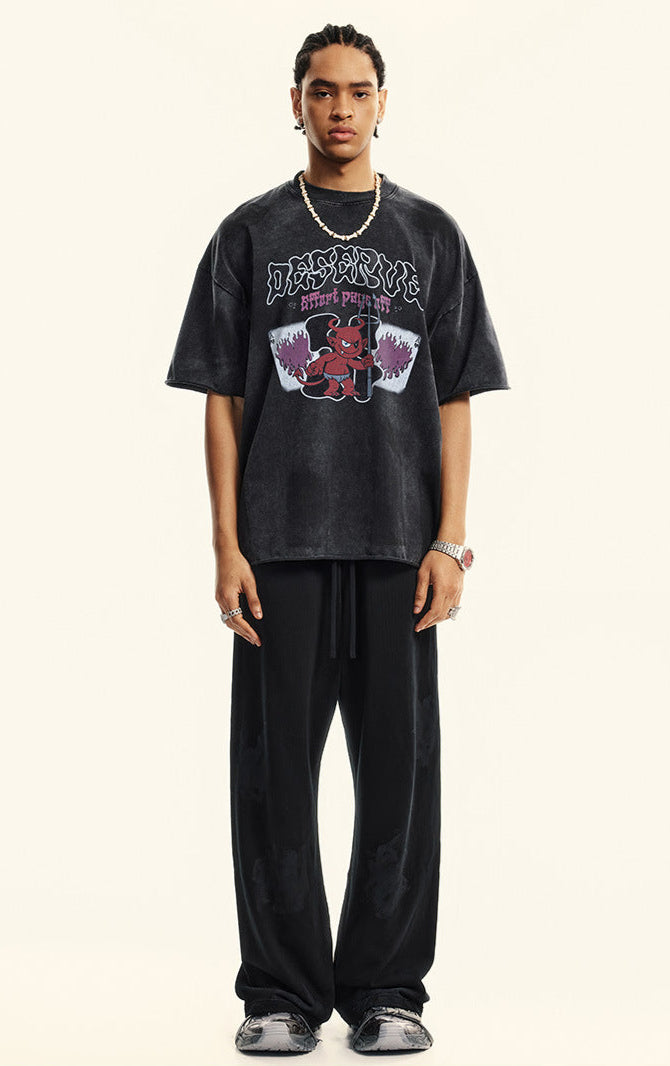 Full body front view of model in black "Deserve" devil graphic tee.