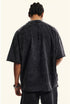 Back view of man wearing washed black oversized graphic T-shirt.