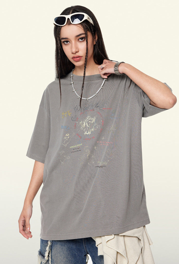 Female model in light gray oversized tee with graffiti art and white sunglasses