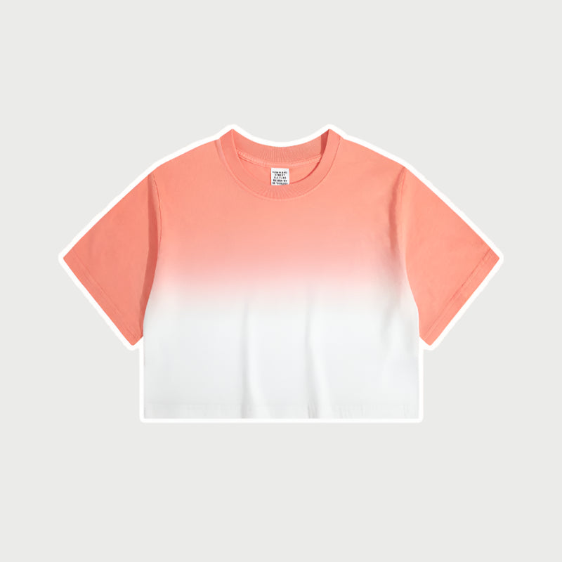 Coral and white ombré cropped short-sleeve t-shirt with gradual color fade from deep blue to white, featuring a crew neck and a small branded tag at the collar