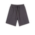 Charcoal gray cotton shorts with elastic waistband and drawstring ties, featuring a relaxed fit and clean minimal design against white background