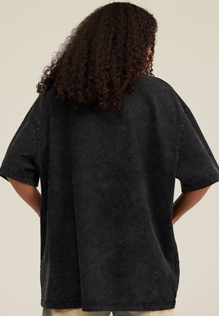 Back view of model wearing washed black angel T-shirt, plain back design visible.