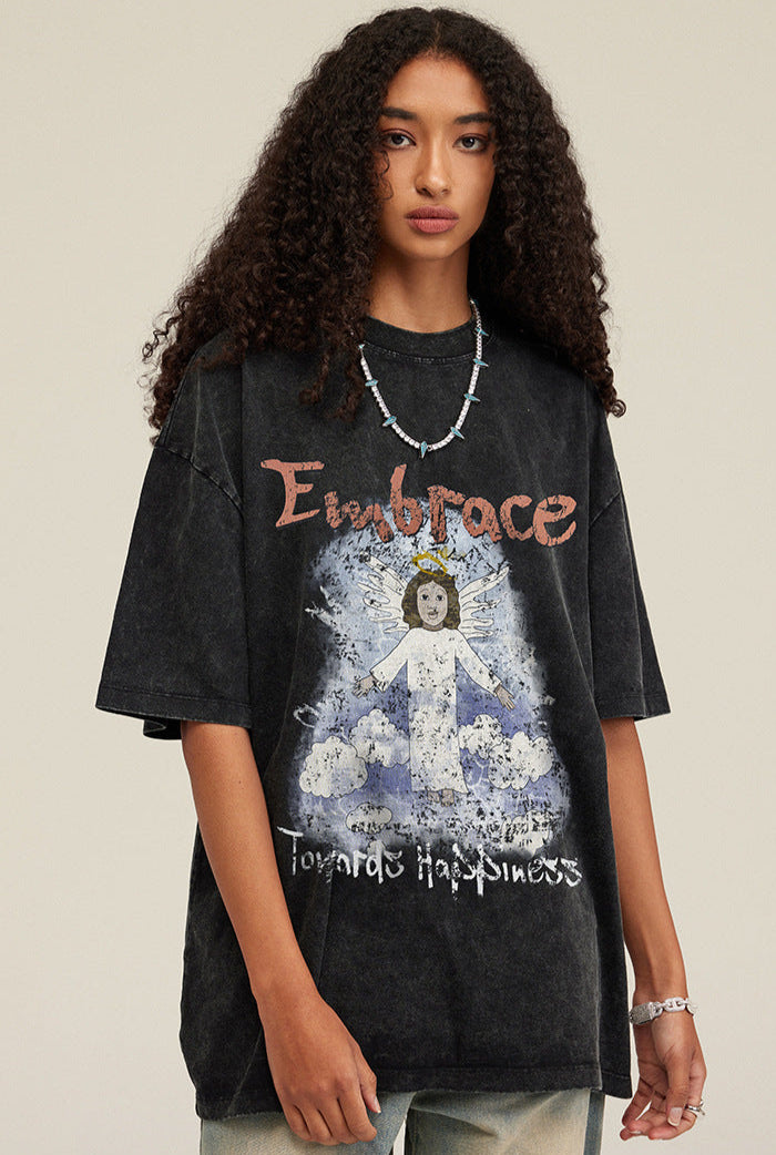 Front-facing close-up of model wearing black angel graphic tee, showing detailed print and jewelry.