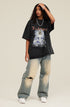 Model wearing black angel T-shirt and distressed jeans, tilting head and touching hair.