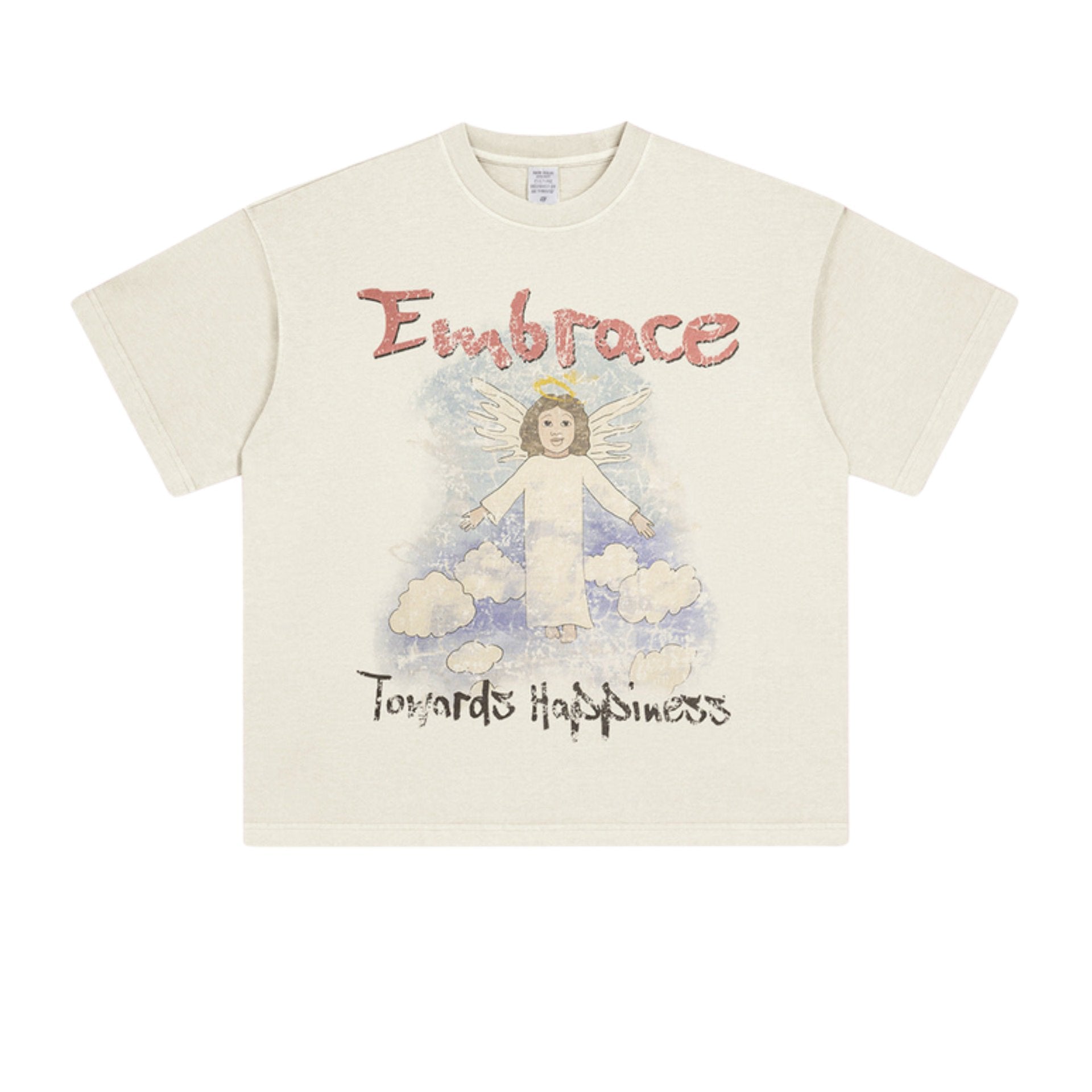 Flat-lay of cream-colored graphic T-shirt with red 'Embrace' text and angel illustration above 'Towards Happiness' text.