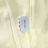 Label on a piece of light yellow fabric indicating 100% cotton.