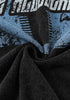 Wrinkled close-up of graphic print on soft black fabric.