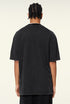 Back view of plain black oversized T-shirt worn by model.
