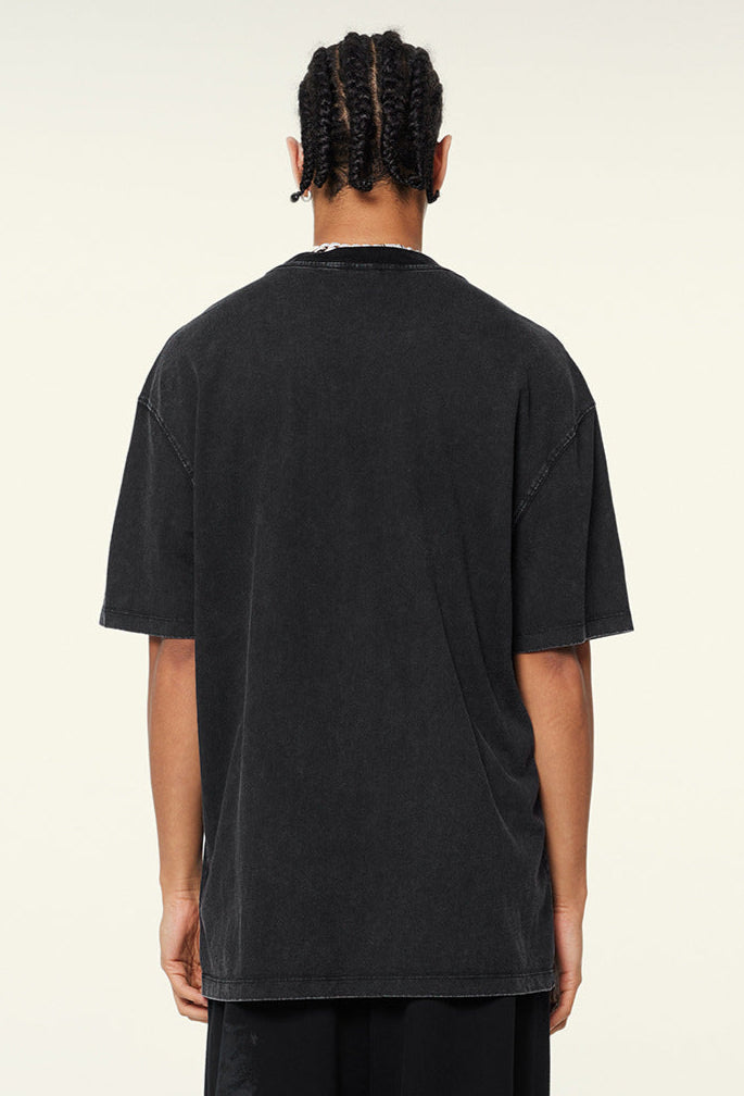 Back view of plain black oversized T-shirt worn by model.