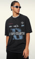 Side view of model in oversized black graphic tee with bold text.