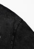 Close-up of shoulder seam stitching on black tee.