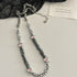 Beaded necklace with silver and black stones and pink evil eyes.