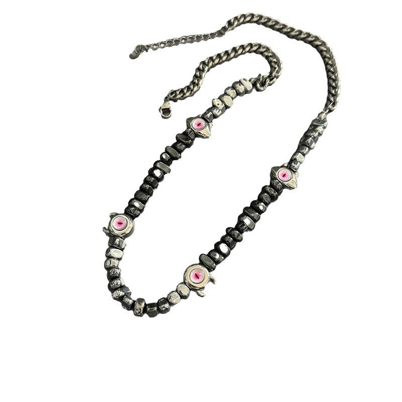 Evil eye beaded necklace with chunky metal chain on white background.
