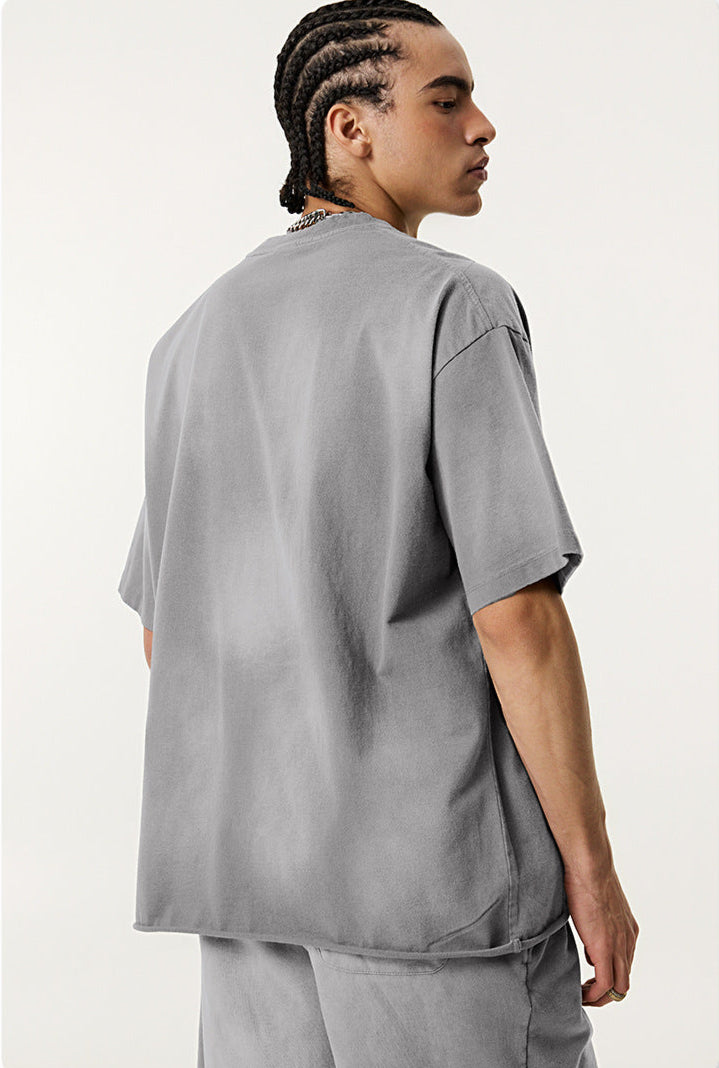 Model wearing grey Eyes Fade tee from back, showing plain rear design and relaxed cut.