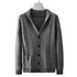 Dark gray knit cardigan displayed on hanger showing textured front panels, button closure, and ribbed collar details