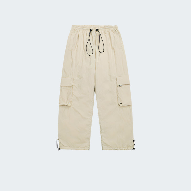 Cream-colored cargo pants product photo showing full-length view with cargo pockets and drawstring details