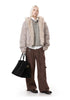 Full-body view of taupe faux fur hood bomber jacket styled over a grey sweater and brown cargo pants.