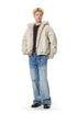 Full-length shot of beige relaxed fit winter bomber jacket styled with blue jeans.