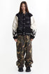 Full-length styling of the embroidered varsity jacket with wide camouflage pants