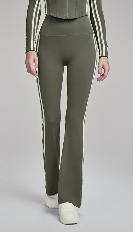 Woman wearing army green flare leggings with white side stripes.