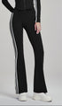 Woman in black flare leggings with white side stripes, standing at an angle.