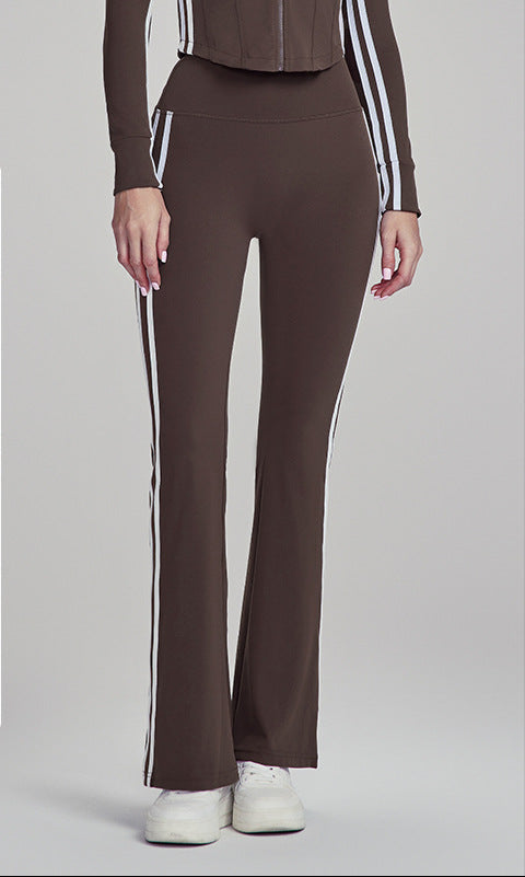Woman modeling chestnut brown flare leggings with side stripes, hands relaxed.