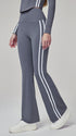 Woman modeling sea rock grey flare leggings with white stripes in side view.