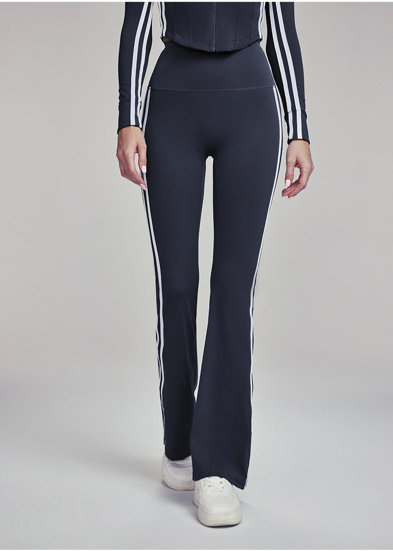 Woman wearing navy blue flare leggings with white stripes, front view.