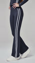 Navy flare leggings with white stripes, shown from side while model rests one hand on hip.