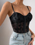 Black floral mesh corset top with underwire cups and sheer bodice, paired with light-wash jeans.