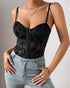Close-up of black mesh corset with velvet floral design and sweetheart neckline.