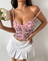 Pink floral mesh corset top with sculpted cups and hook front, worn with white tennis skirt.