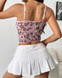 Back view of pink floral mesh corset with adjustable straps and white tennis skirt.