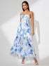 Woman wearing a blue floral slit dress on a white background