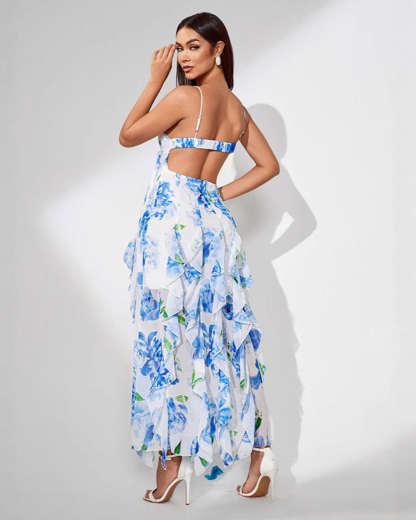 Woman wearing a blue ruffle slit floral dress on a white background