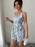 Side view of belted floral summer romper with blue and white print